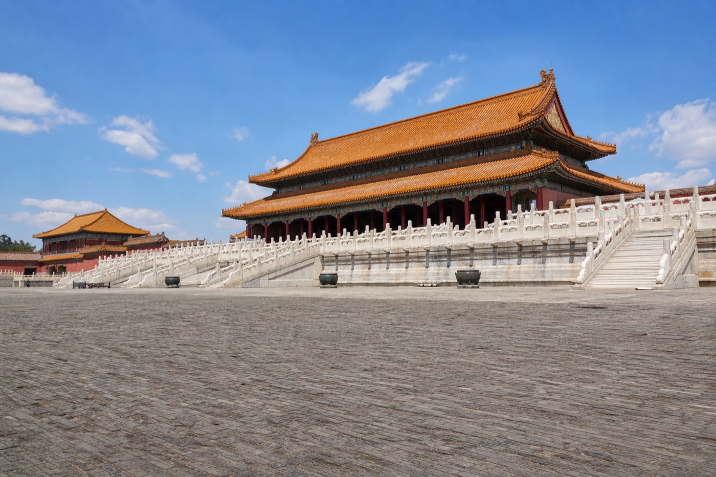 A wide, sweeping stone courtyard inside the Forbidden City stretching toward a distant golden-roofed hall